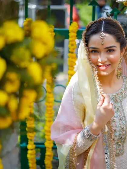 A beautiful portrait of the bride before the haldi ceremony begins, framed by yellow marigold flowers.