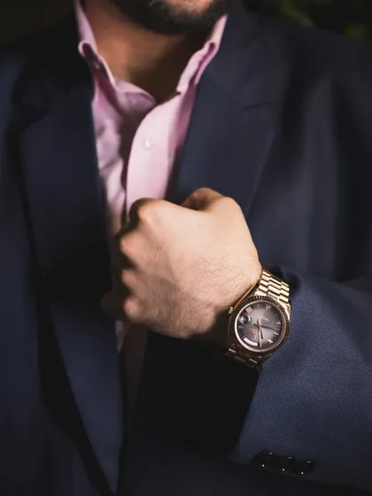 A detail shot of the groom's watch and suit cuff.