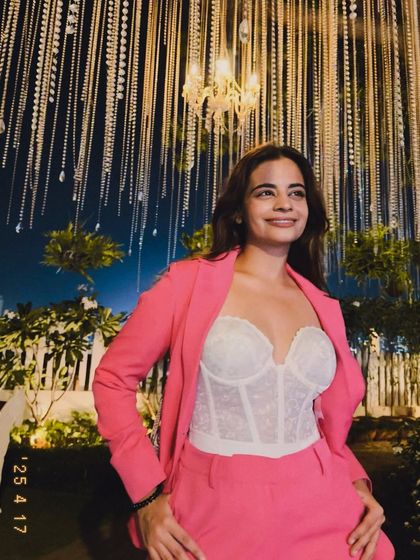 A candid smile from the same event. This look, combining a structured corset with tailored pants, is a great way to play with silhouettes and create a powerful, stylish outfit.