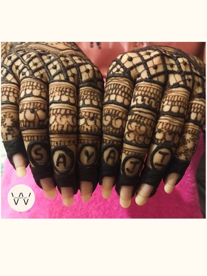 Personalizing henna is my favorite thing to do. Here, the bride's name is artfully hidden within the detailed finger designs.