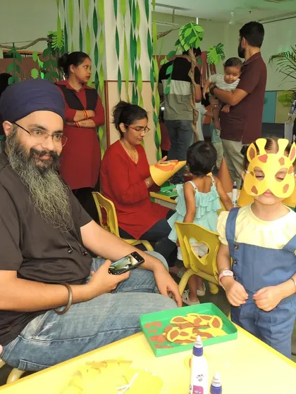 During our 'Jungle Joyland' event, a father and child work together on a creative craft activity. We design these events to encourage family bonding and shared learning.