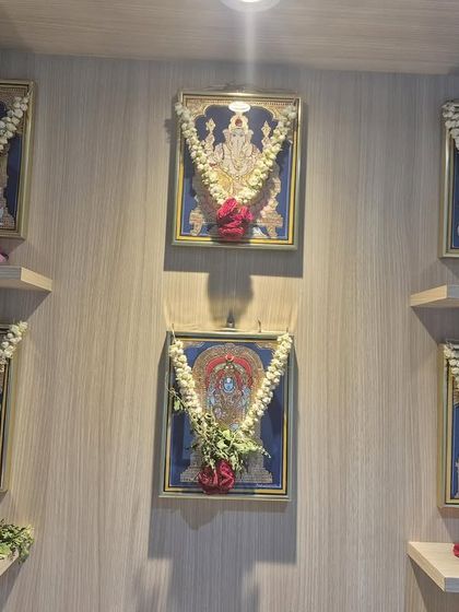 A still shot of the set of 6 paintings in our client's pooja room. The arrangement with fresh flower garlands enhances the devotional atmosphere.