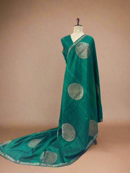A unique pure Dupion Banarasi silk saree in green with large, woven circular motifs.