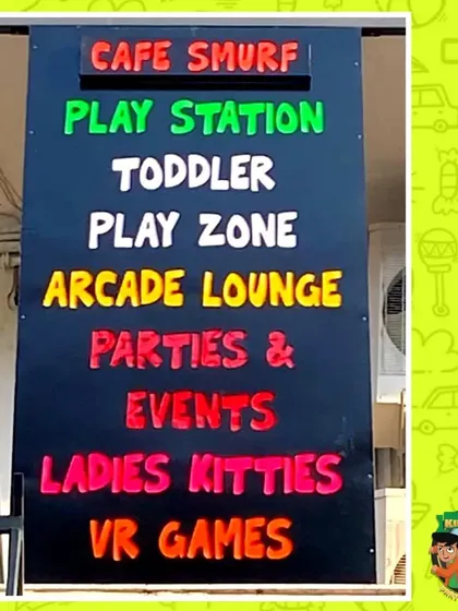A colorful sign listing all the different attractions available under one roof: Cafe Smurf, Play Station, Toddler Play Zone, Arcade Lounge, and more.