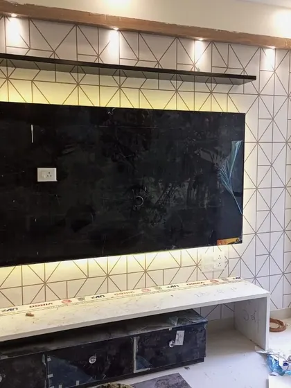 A modern geometric wallpaper with a clean, white background and thin gold lines, installed as a stylish backdrop for a TV unit. This design adds a touch of contemporary elegance without overwhelming the space.