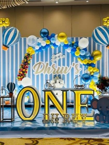 A wide view of the 'Up and Away' safari theme, showing the full stage with animal props and hot air balloons in a grand hall.