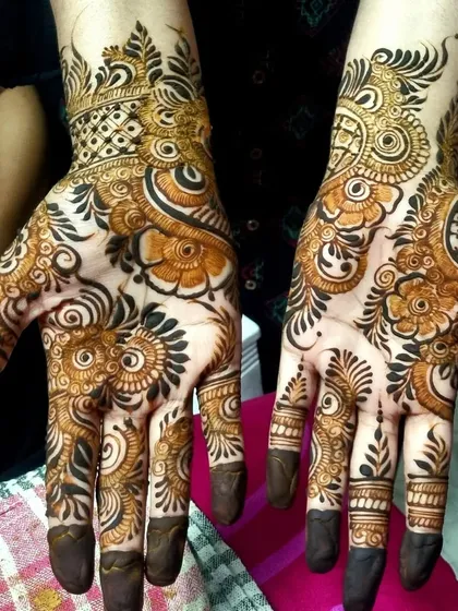 A classic Indo-Arabic design. The bold outlines and shaded florals create a strong visual impact, while the delicate netting on the fingers adds a touch of intricacy.