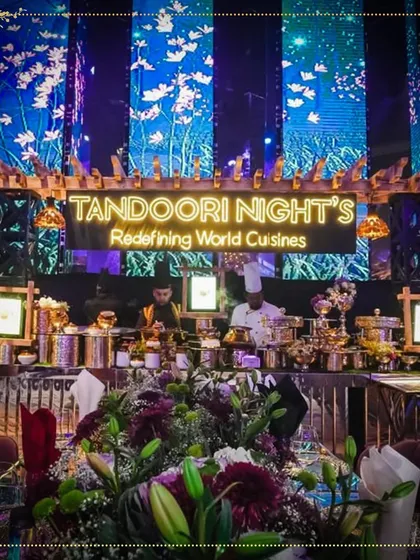 Our tempting station at a glam night, featuring a stunning floral centerpiece and a wide array of dishes served from elegant brass pots.