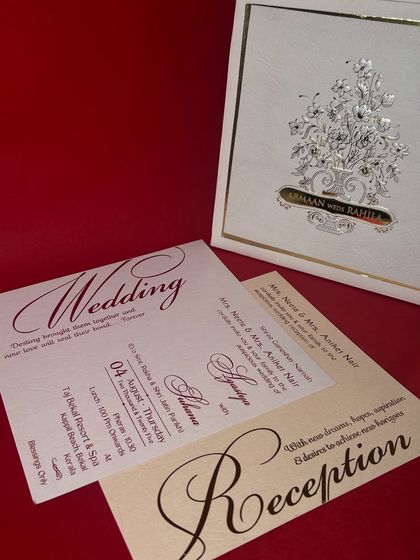 A timeless and elegant choice, this invitation box features a beautiful silver-foiled floral bouquet on a textured ivory base. The accompanying inserts use classic calligraphy, perfect for a sophisticated and formal wedding celebration.