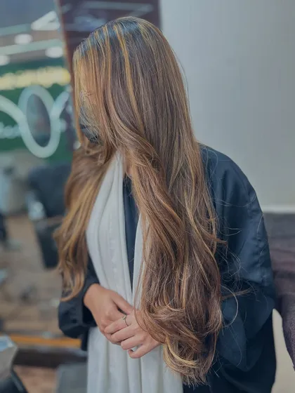A candid, stylish shot of our honey blonde balayage. The way her hair covers her face adds a bit of mystery and highlights the beautiful color.
