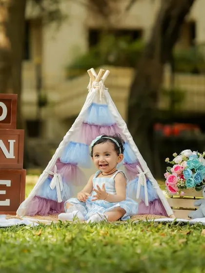 A happy, clapping moment captured in the park. Outdoor sessions are perfect for energetic toddlers.