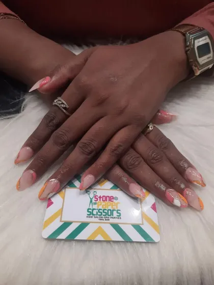 This design features colorful swirls on the tips of the nails, creating a subtle pop of color against the natural base. It's a fun, abstract look for medium-length nails.