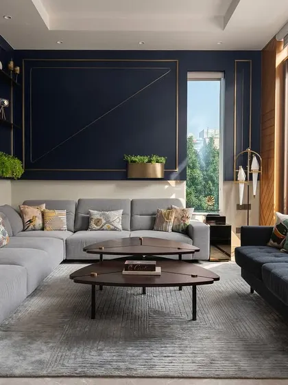 This modern luxury residence showcases a harmony of bold elegance and playful creativity. The living area is defined by a deep blue feature wall with brass inlays, paired with contemporary furniture and ample natural light to create a space that nurtures family life.