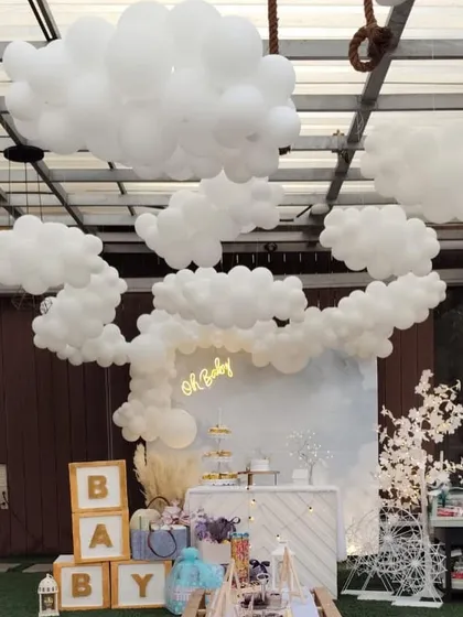 A wider view of the "Oh Baby" shower, highlighting the impressive ceiling installation of balloon clouds that float above the entire setup.