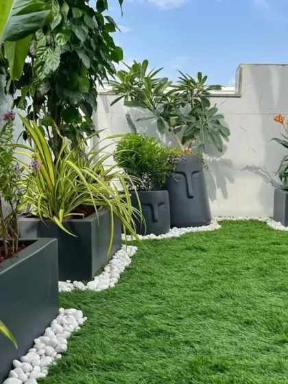 A beautifully finished terrace garden featuring lush artificial turf, modern planters, and decorative white pebbles. This demonstrates my eye for detail and ability to create complete, aesthetically pleasing outdoor living areas.