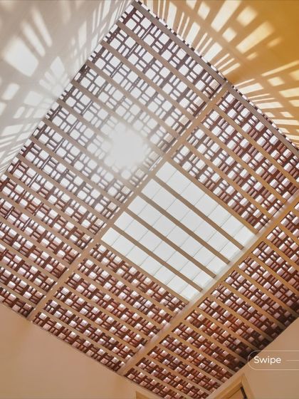 A stunning view of the sun shining through a patterned skylight at the Raghavendra Residence. This is a perfect illustration of how a structural element can become a primary source of beauty and dynamism in a space.