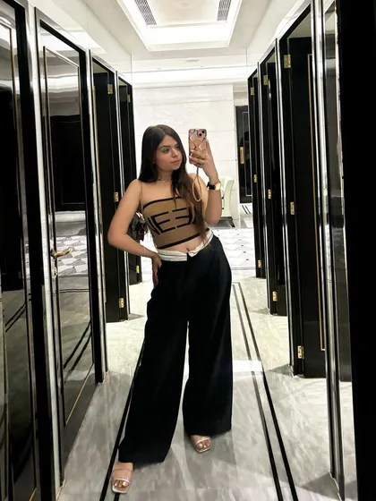 A full-length mirror selfie of the same stylish outfit in a hallway.