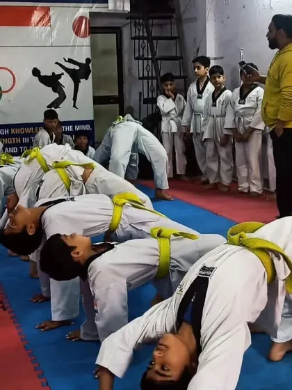 Students practicing backbends to improve flexibility, a key component evaluated during belt tests.
