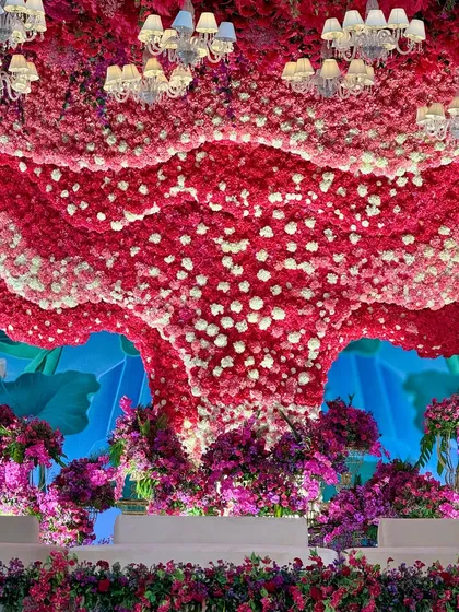 A look up at the grandiose floral ceiling. The combination of red and white flowers, dotted with small chandeliers, is nothing short of surreal. ✨