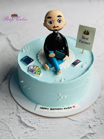A custom cake for a partner, featuring a handcrafted fondant figure that looks just like him. The design includes personal touches that reflect his personality and hobbies.