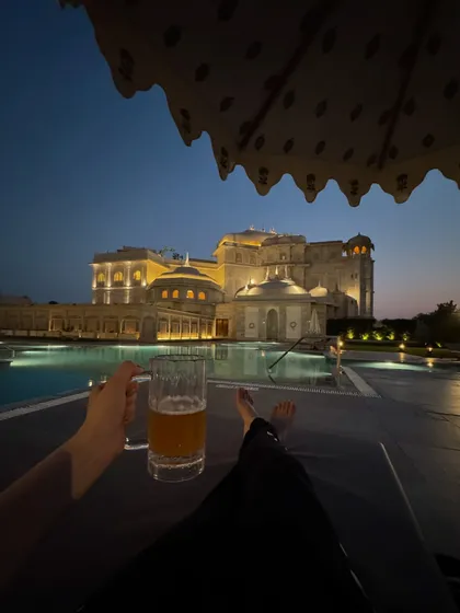 Capturing the serene moments of a luxury hotel stay. This shot from the Fairmont Jaipur shows the stunning poolside ambiance at dusk, selling an experience of relaxation and opulence that goes beyond just a room.