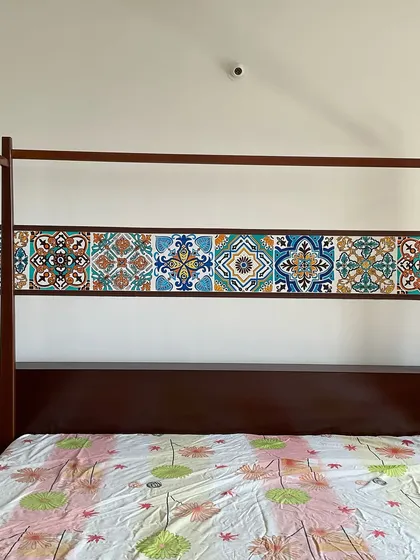 This hand-painted Moroccan tile mural serves as a unique headboard in a bedroom. Instead of using actual tiles, I meticulously painted each pattern to create a seamless and customized look that adds a vibrant, ethnic touch to the room's decor.