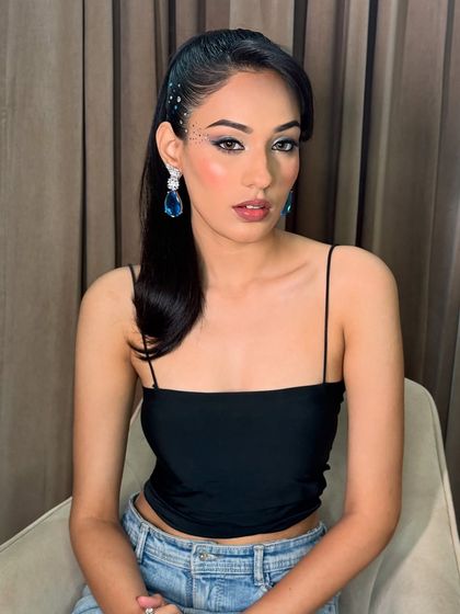 The full look in a relaxed pose. This makeup is perfect for a night out, balancing a creative eye with a sleek hairstyle and a simple outfit.