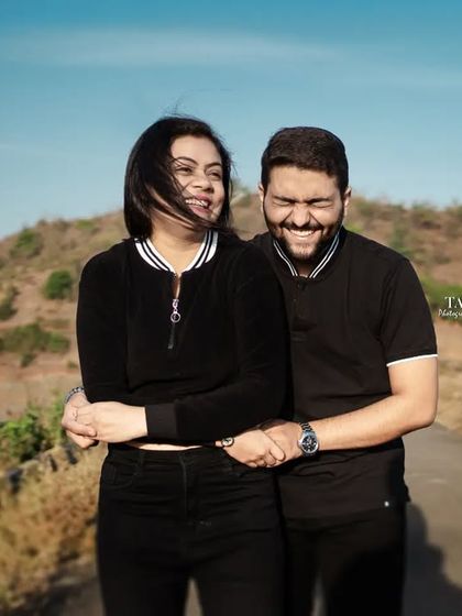 A candid moment of laughter and joy on a country road. The wind in her hair and their shared smiles make this a perfect example of a natural and happy pre-wedding photo.