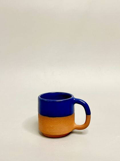 A single cobalt blue and terracotta mug. The contrast between the raw clay and the vibrant glaze is a signature part of this design, bringing beauty to your everyday routine.
