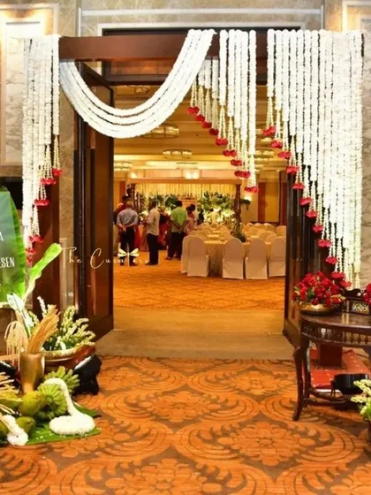 Welcoming guests into a celebration of love. This entrance for an engagement at the Taj Coromandel features elegant tuberose garlands and a traditional welcome setup, promising a memorable event from the very first step.
