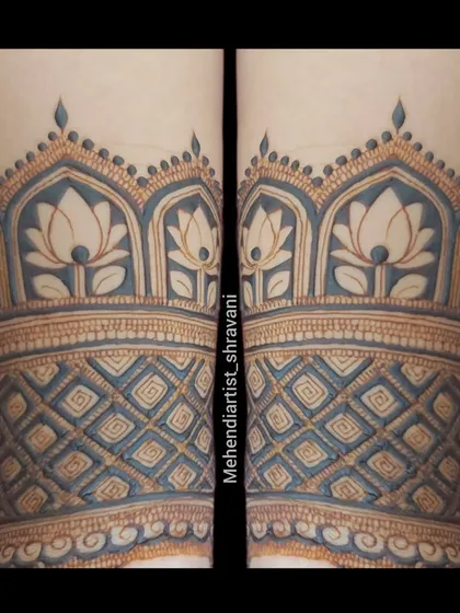 A close-up of a forearm band with a beautiful blue-tinted effect. This shows how traditional lotus and dome patterns can be given a unique visual twist.