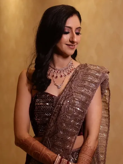 A candid smile from the bride during her reception. The soft lighting highlights the shimmering details in her eyeshadow and the radiant finish of her skin.