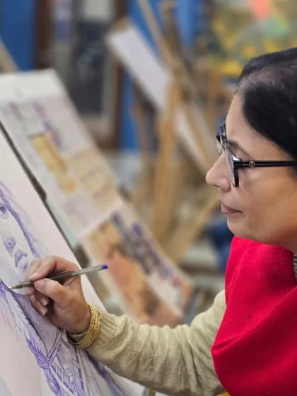 A side profile of a student concentrating on her portrait. Our studio is a place for focused learning and artistic development.
