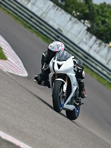 A rider on a Triumph Daytona 675 navigating an incline on the track.