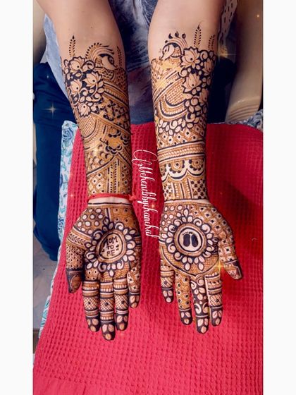 A full baby shower mehendi for the mom-to-be. The design includes baby feet inside a central mandala, surrounded by beautiful floral and peacock patterns.