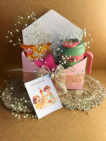Big love for a little sister. This adorable pink-themed hamper includes a personalized sipper, snacks, and a cute Rakhi card, all wrapped up with baby's breath.