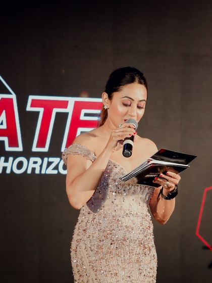 Reviewing my notes on stage to ensure a smooth flow. I am meticulous in my preparation for every corporate event, big or small.