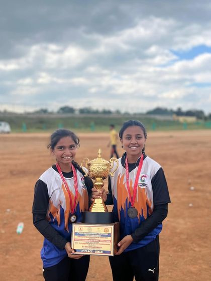 Our junior girls, Spoorthi and Vineetha, proudly holding the 2nd runner-up trophy from the state-level netball championship.