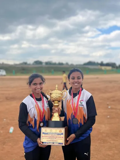 Our junior girls, Spoorthi and Vineetha, proudly holding the 2nd runner-up trophy from the state-level netball championship.