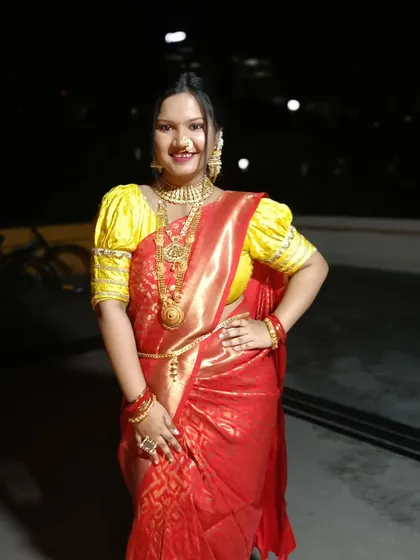 A full-length shot showing the bride's complete attire. The saree is draped elegantly, and her posture exudes the grace of a traditional Maharashtrian bride.