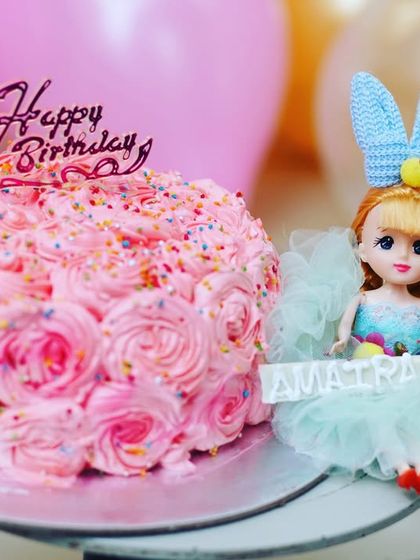 A pretty pink rosette cake next to a doll topper for Amaira's birthday. I focus on the little details that make your child's celebration unique.