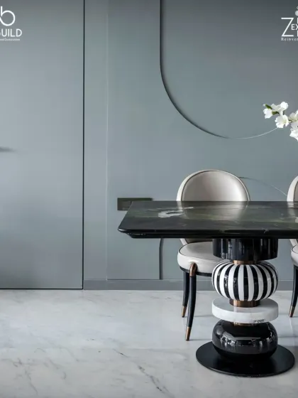 The dining table in 'The House of Arcs' features a unique, sculptural base with black and white striped details, turning a functional item into a piece of art.