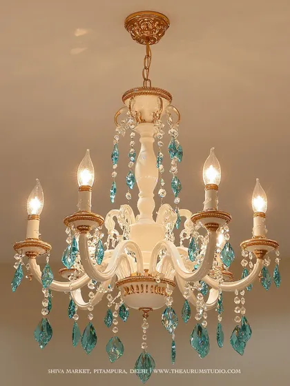 A classic white and gold chandelier adorned with striking turquoise crystals. I love adding a pop of color like this to a traditional design; it personalizes the piece and turns it into a unique family heirloom.