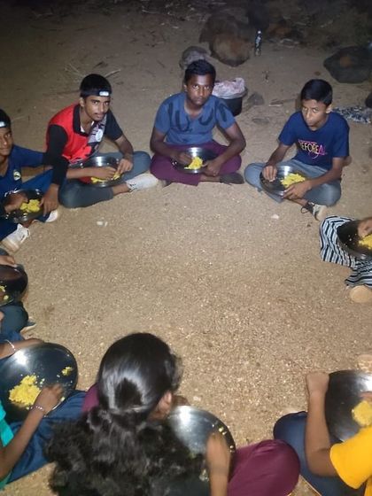 Participants share a meal cooked over the campfire, a classic and rewarding camp experience.