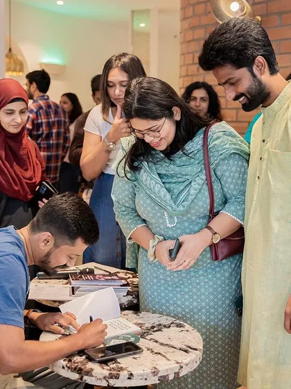 More happy readers getting their books signed, showcasing the diverse community that attends our literary events.
