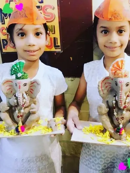 Two sisters proudly displaying their matching eco-friendly Ganpati idols. It's so heartwarming to see siblings bonding over this creative and spiritual activity.