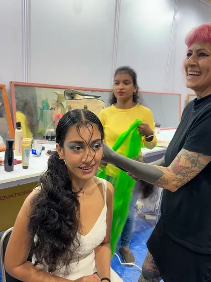 A behind-the-scenes moment from the hair show. Here I am, getting a model ready, adding the final touches to a look that blends high fashion with an eco-conscious message.