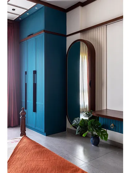 After: A dramatic bedroom makeover featuring a bold peacock blue and rust orange color scheme. The custom wardrobes and new layout completely changed the feel of the room. Swipe to see the before.