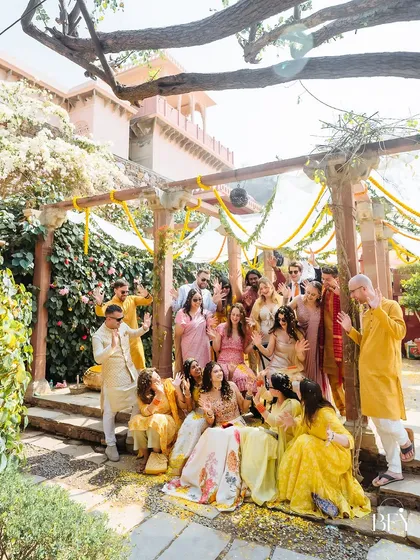 A happy group photo of the bride with her entire bride squad and guests at the Fort Neemrana Haldi.