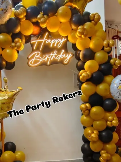 A full view of the black and gold balloon arch, perfect for a sophisticated birthday celebration at home.